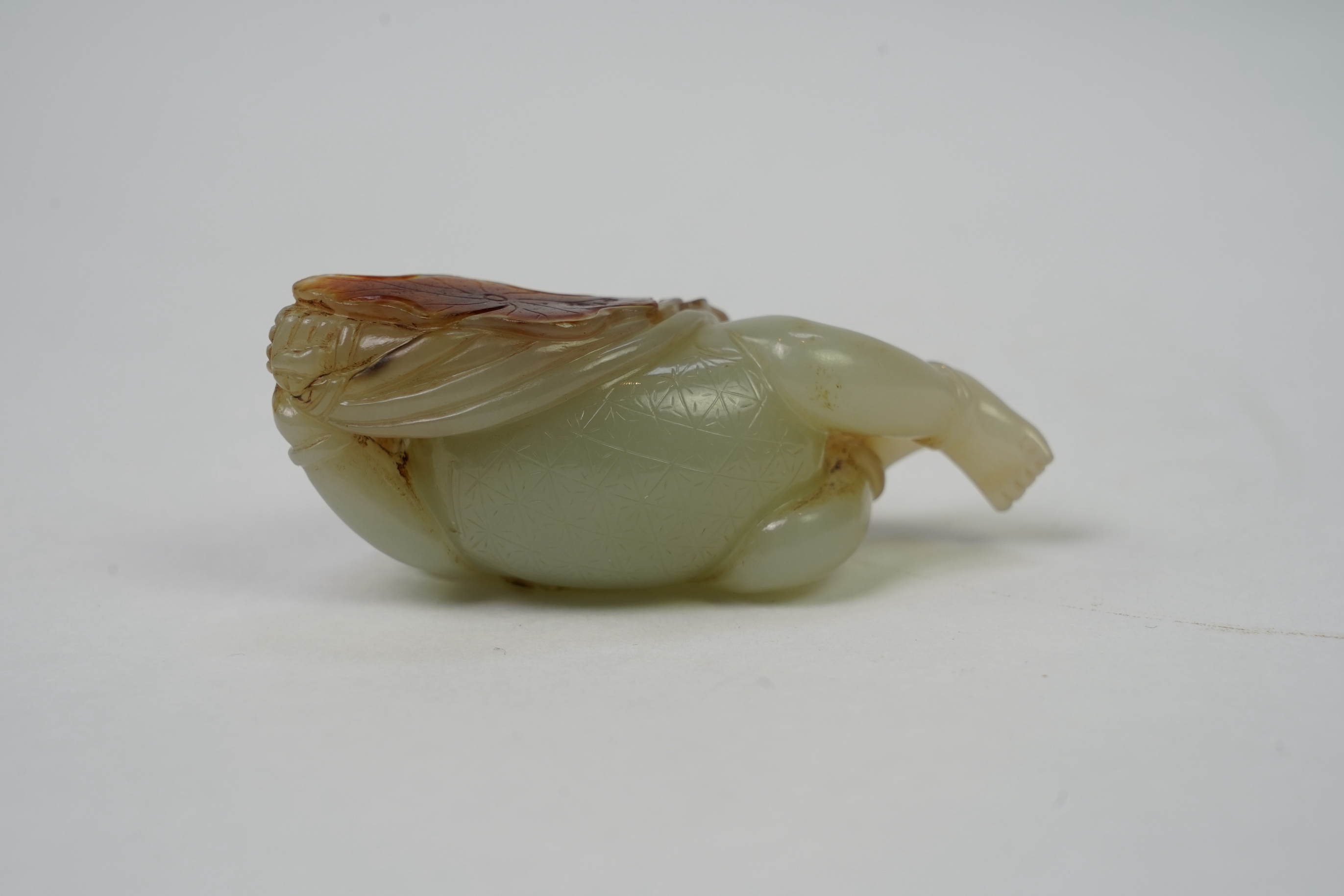 A Chinese pale celadon and russet skin jade figure of a boy and lotus